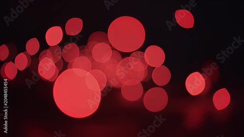 Abstract red bokeh lights glowing in dark background with soft focus circular shapes