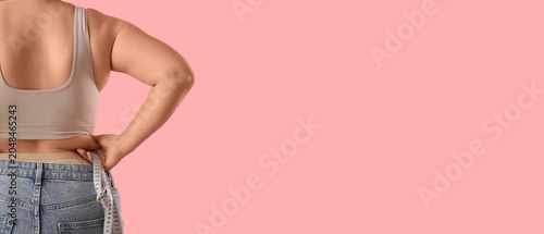 Tableau sur toile Overweight woman with tape measure on pink background, back view
