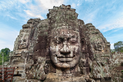 Foto Iconic serene stone faces carved into the towers of the ancient Bayon temple com
