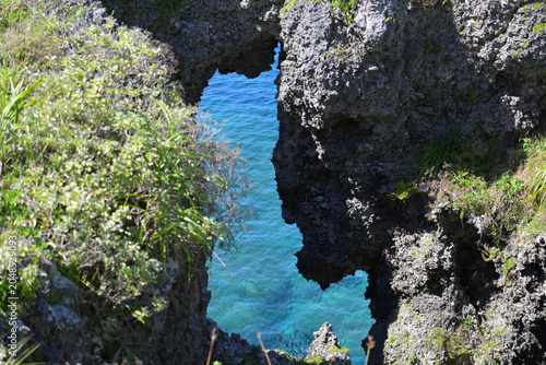 Foto 断崖絶壁の岩肌の隙間から見えるエメラルドグリーンの美しい海