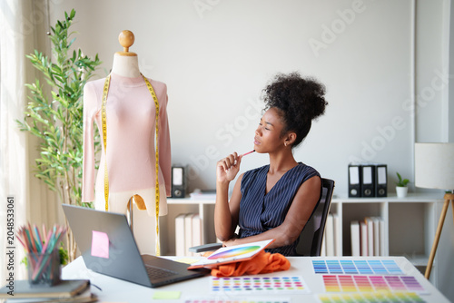 Fotografie Female fashion designer actively working and thinking in a modern design studio,