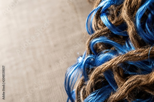 Macro Close-up of Intertwined Coarse Jute Fibers and Vibrant Blue Silk Thread with Minimalist Neutral Background and Negative Space