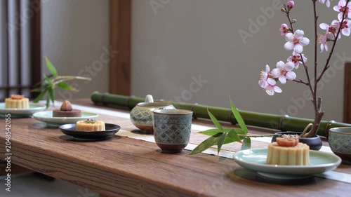 Japanese style tea ceremony table with desserts and sakura blossoms