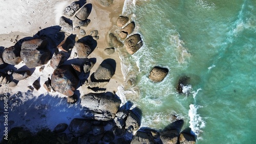 Foto Aerial Top Down View of Granite Boulders and Turquoise Waves at Squeaky Beach Au