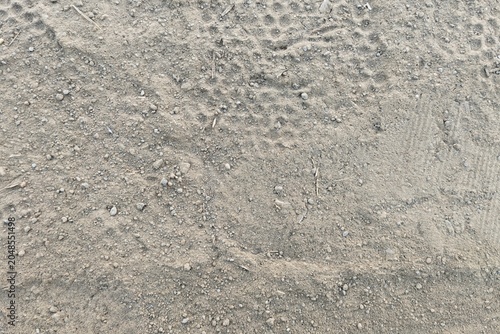 Top view of fine sand texture with faint vehicle tire tracks.