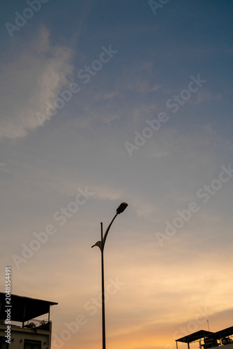 Silhouette of a street lamp against a colorful sunset sky.
