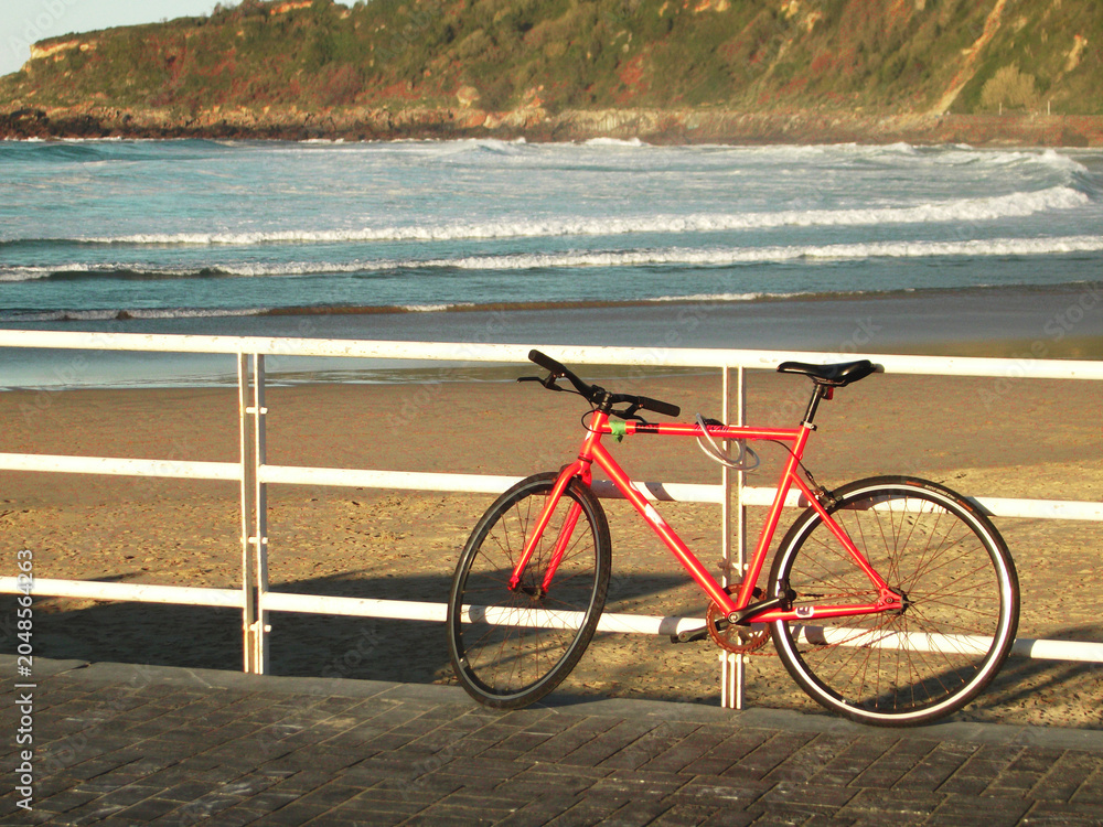 Fototapeta premium Una bicicleta aparcada afuera de una playa de arena
