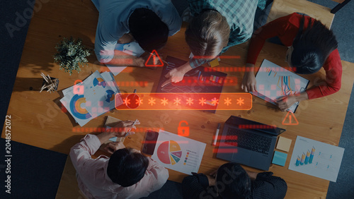 Fotografie A diverse group of professionals collaborates at a wooden table, analyzing data with charts and laptops in a modern workspace emphasizing teamwork and security