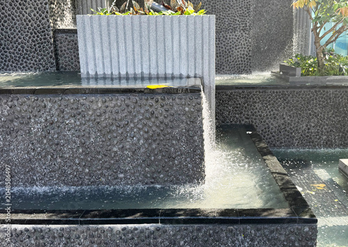 Black stone aggregate waterfall wall background.
