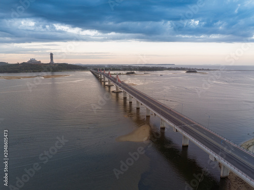 Elevated drone perspective of Co Louy Bridge extending across calm estuary waters toward the coastline at twilight.