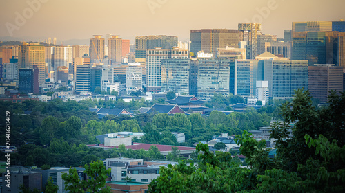 Foto Gyeongbokgung Palace surrounded by modern skyscrapers in Seoul at golden hour su