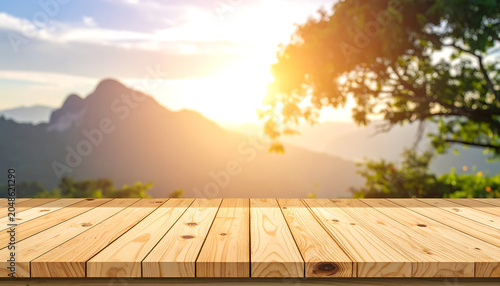 Empty wooden table in foreground with blurred mountain landscape and golden sunset sky, perfect for product display