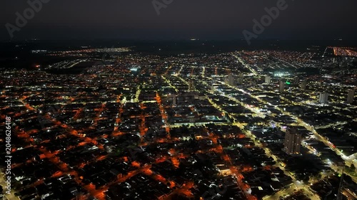 Aerial view of a sprawling city at night with illuminated streets and buildings creating a vibrant urban landscape