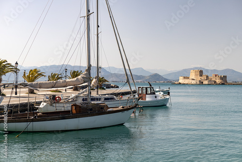 Принти на полотні Voiliers amarrés à un port sur une mer calme face à un fort