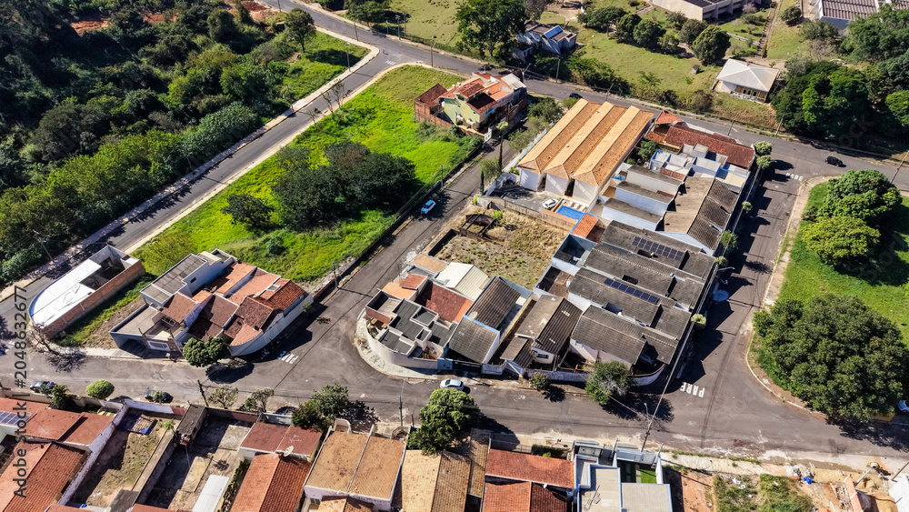 Fototapeta premium Aerial view of a residential neighborhood with houses and streets under a clear blue sky