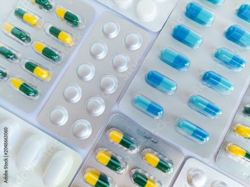 Canvas-taulu Medical pills, tablets, capsules in various colors and shapes inside blister packs, arranged on white background, for healthcare, drugs, medications, dosage, pharmacy, medicine packaging concepts