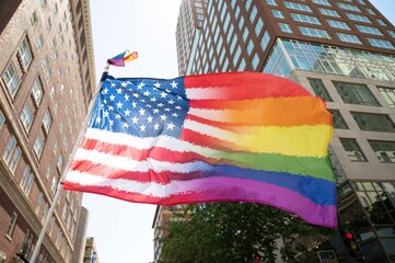 American Flag Pride Flag waving in city