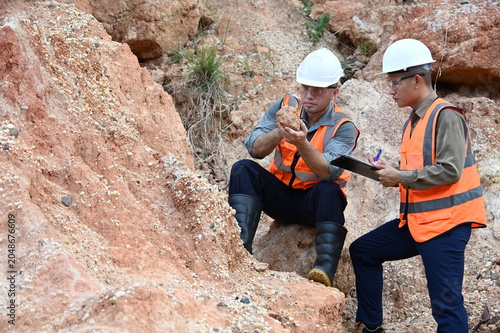 Geologists conducting field inspection and geological survey at an excavation site. Professionals analyzing soil, rock formations and subsurface conditions for mining, construction and exploration pro