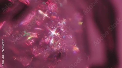 A vibrant video captures sparkling crystal formations in a dark pink environment with shiny light effects and reflections.