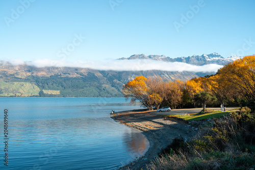 Autumn scenery by the lakeside and the sea of clouds over distant mountains, Lake Wakatipu, New Zealand