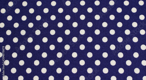 Close up of blue cloth with white polka dots. Texture of classic polka dot pattern cotton fabric background. 