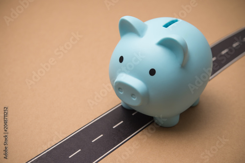 Fotografie Piggy bank walks alone on the road