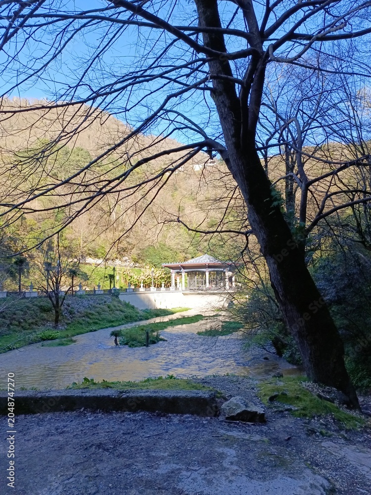 Obraz premium Beautiful lake view with mountains, houses, and clear blue sky during midday