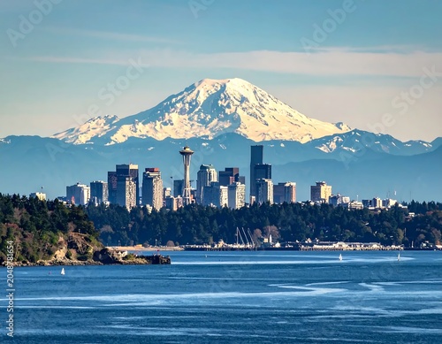 Mountain city skyline at sunrise with waterfront.