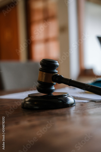 A judge’s gavel stands beside a model car and legal documents, symbolizing auto insurance claims, traffic accidents, liability disputes, compensation, and legal justice.