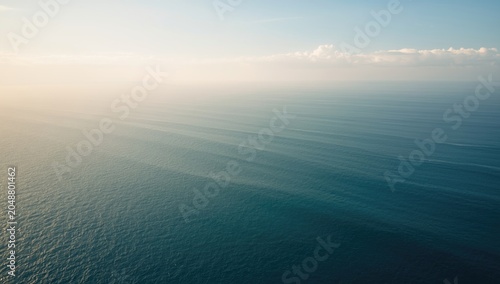 Wide ocean horizon with light cloud cover