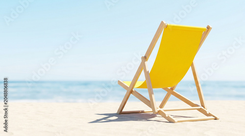 Yellow deck chair mockup on a sandy beach with blue sea background, rear view