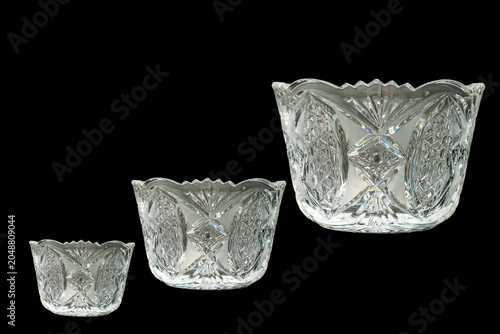 Elegant crystal products isolated on black background, close-up.