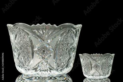 Elegant crystal products isolated on black background, close-up.