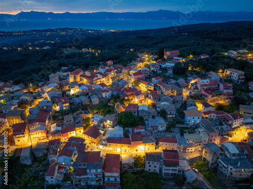 Εκτύπωση καμβά Aerial drone view of Nymfes mountain village at night, Corfu island, Greece, traditional houses lit up