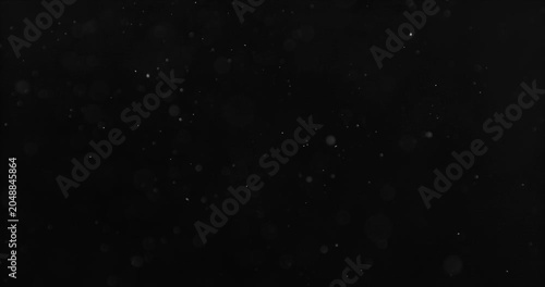 Ultra slow motion airborne dust or snow particles drifting through space on a black background. Perfect cinematic overlay, atmospheric visual effect, compositing element and VFX asset.