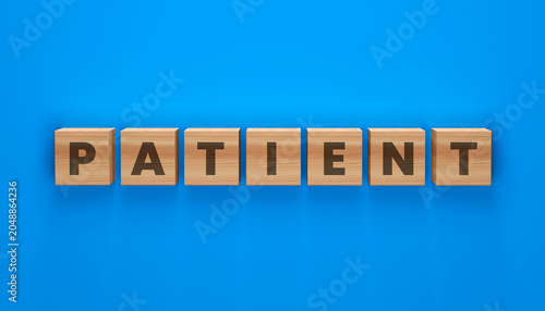 Quadro su tela Patient spelled out in wooden blocks on blue background, concept of patience