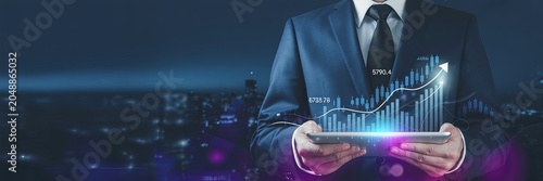 Man in suit holding tablet with glowing stock market graph