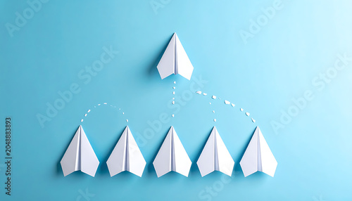 Several paper airplanes flying in formation with one leading the way, representing teamwork and success on a blue background.