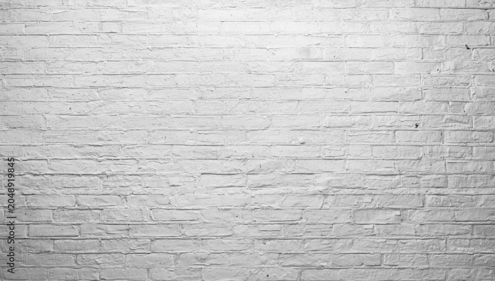 Fototapeta premium Rough white brick wall backdrop offering extensive copy space and high key illumination