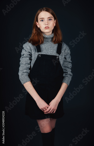 Studio fashion: little girl wearing sweater and sundress. Portrait of sweet child