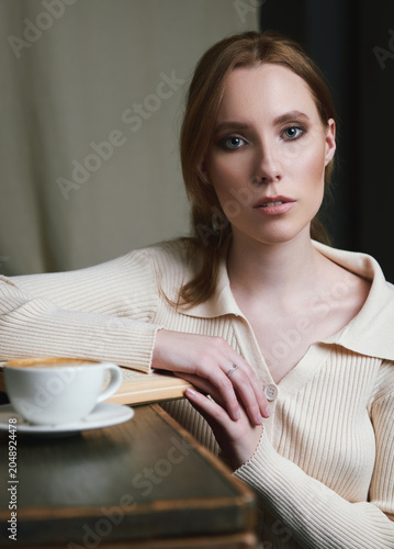 Retro (vintage) style portrait of beautiful young girl with book and cup of coffee