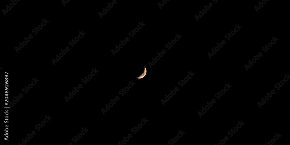 Obraz premium Gentle lunar crescent glowing vividly in a dark navy atmosphere