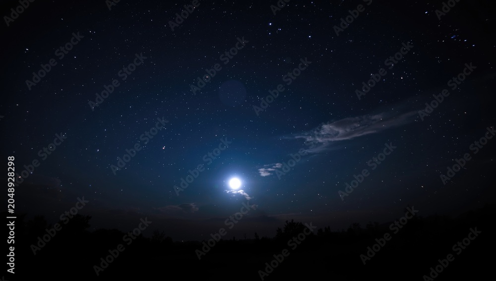 Obraz premium starry nighttime sky showcasing a luminous full moon over horizon