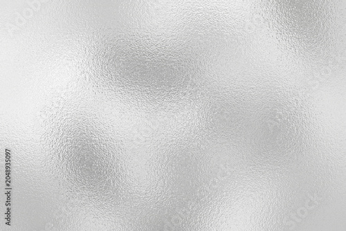 Silver foil background with metallic texture and shiny frosted chrome surface reflection