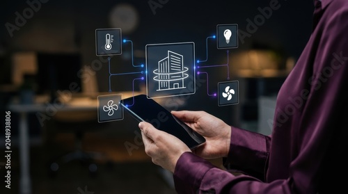 Quadro su tela Professional woman holding smartphone to manage smart building systems through a