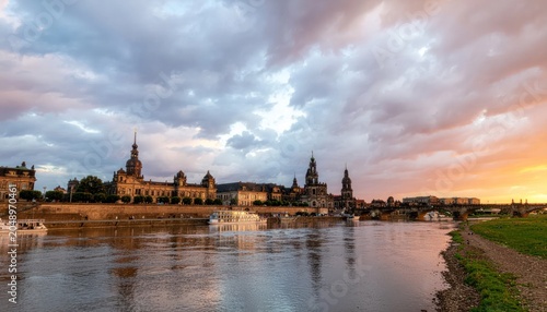 Historic cityscape along serene river sunset.