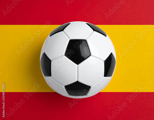 Balón de fútbol sobre la bandera de España, imagen deportiva con colores nacionales, concepto de selección española, competición, mundial de futbol y deporte nacional