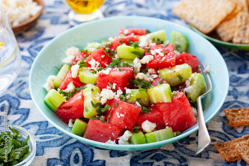Foto Fresh summer watermelon salad with feta cheese and cucumber in blue bowl