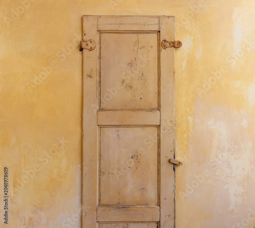 Vecchia porta di legno con muro giallo