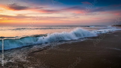 Peaceful ocean waves gently lapping onto sandy beach at colorful sunset  serene natural scenery